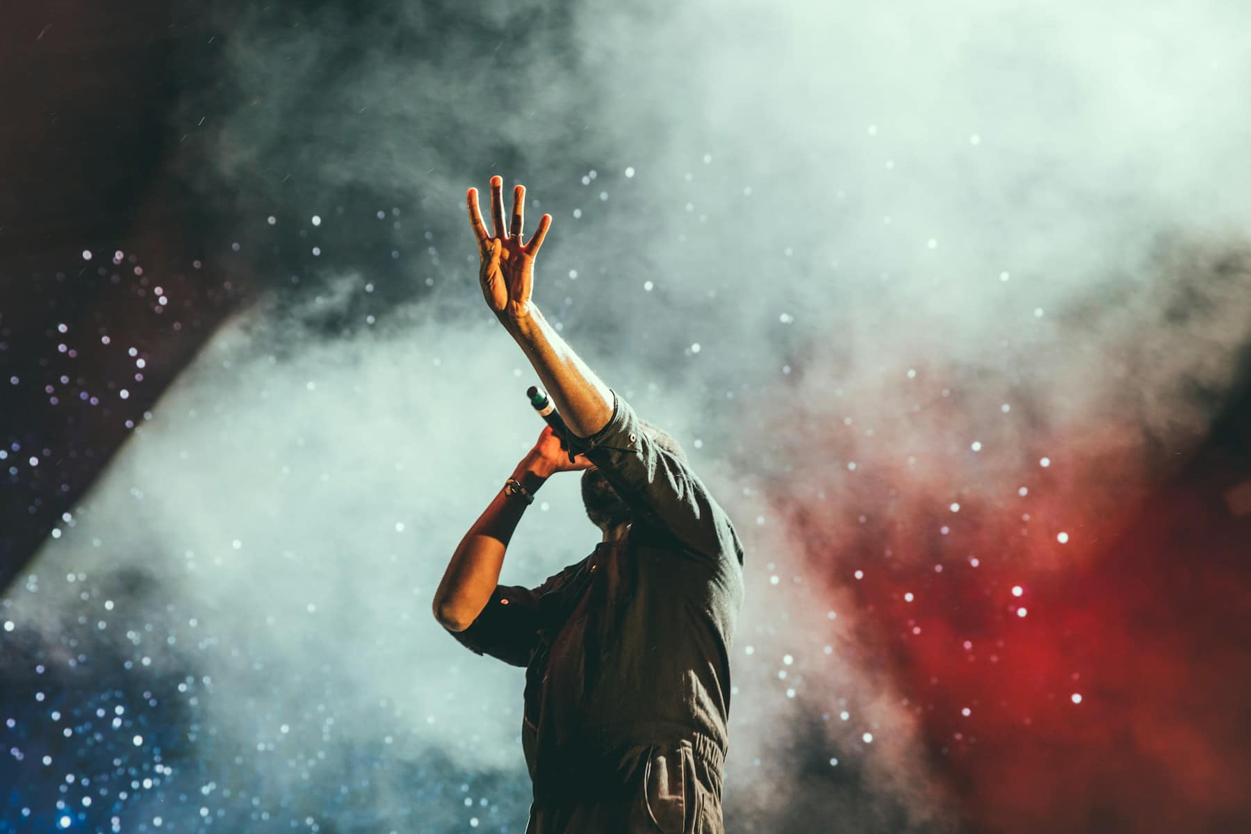 A singer performing beneath cinematic stage lights